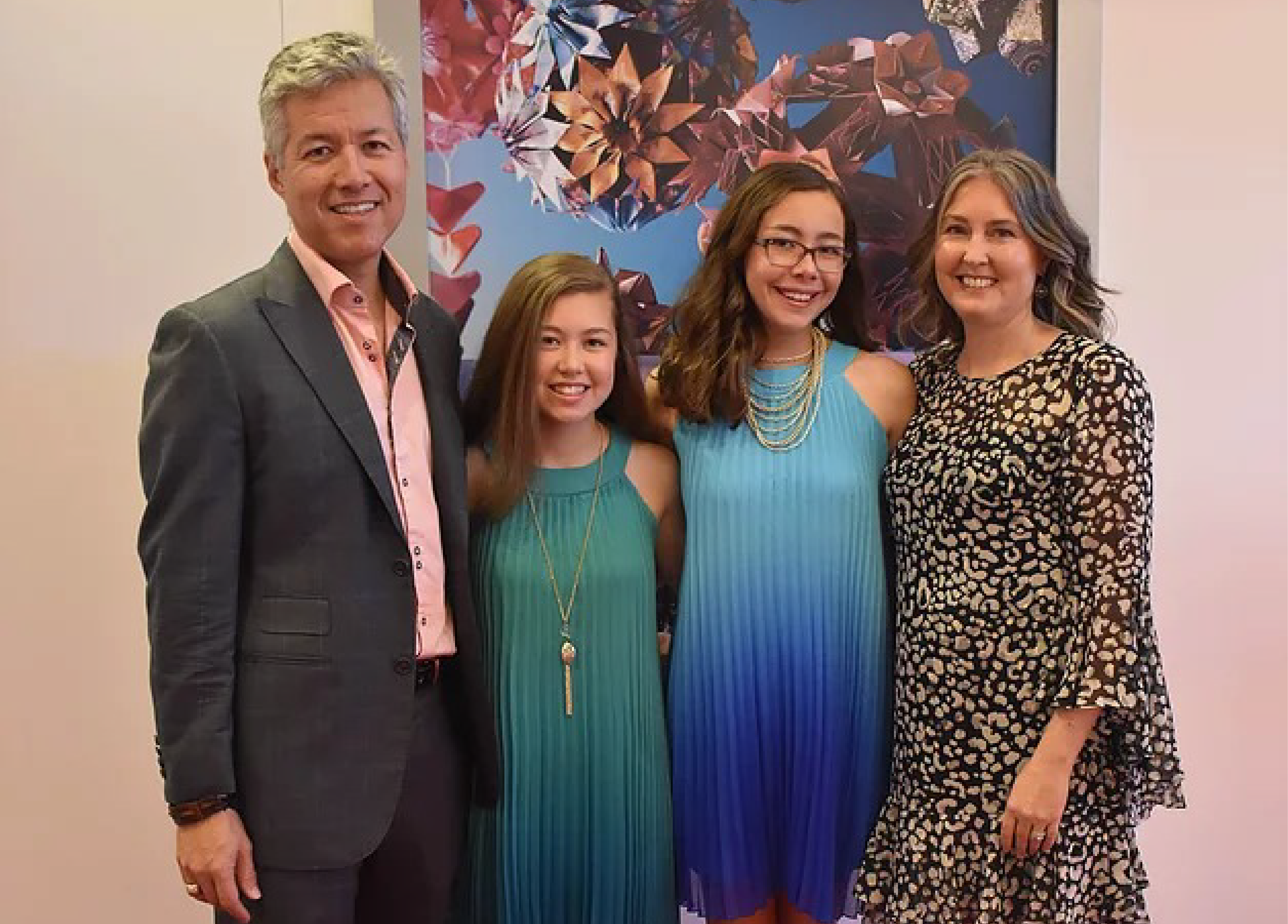 Isabelle and Katherine Adams with their parents in front of an origami artwork